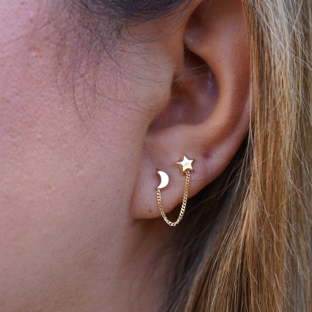 Model wearing 14K Gold Star & Moon Crawler Stud Earrings, showcasing their celestial star and moon design with a dainty, elegant curve along the ear.