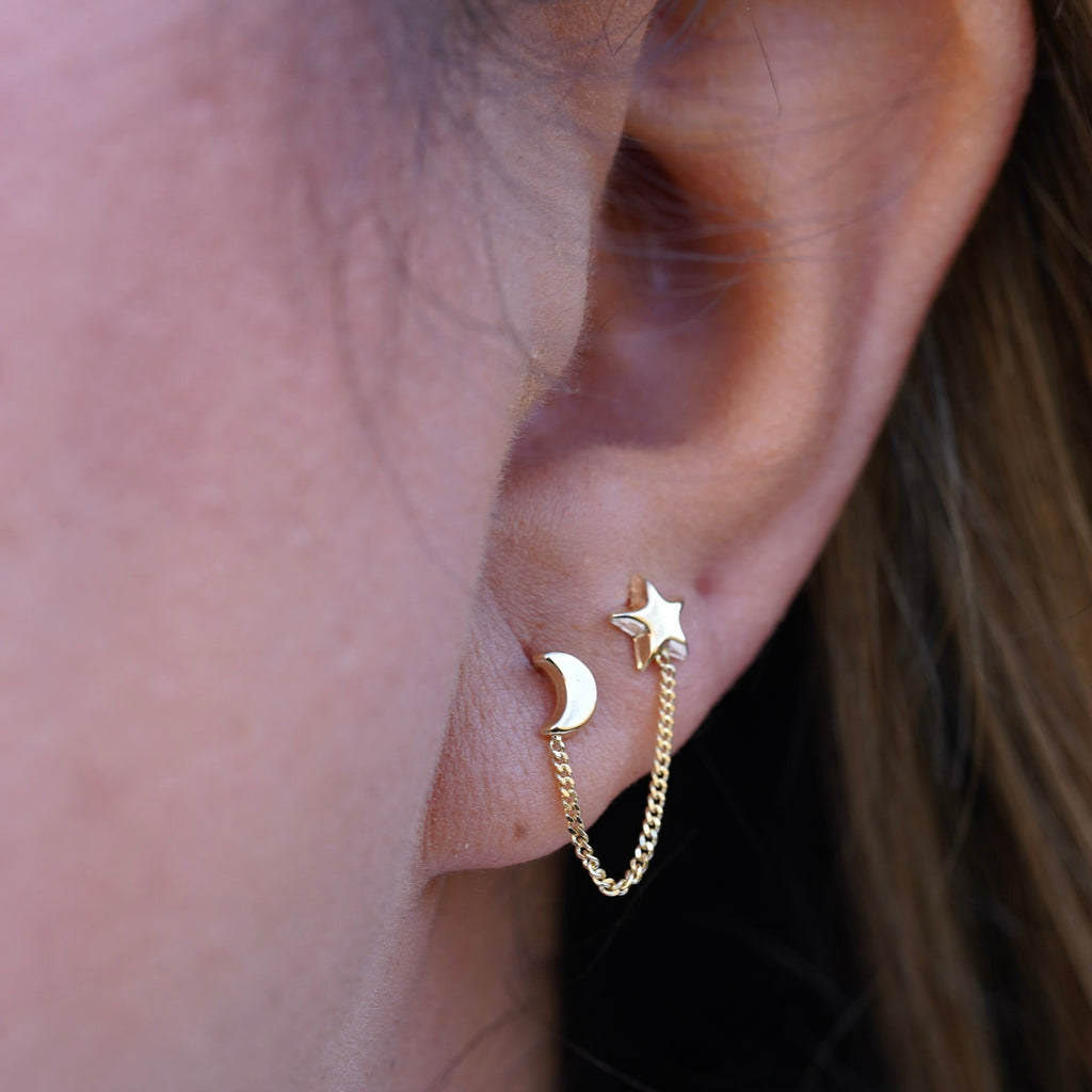 Model wearing 14K Gold Star & Moon Crawler Stud Earrings, showcasing their celestial star and moon design with a dainty, elegant curve along the ear.