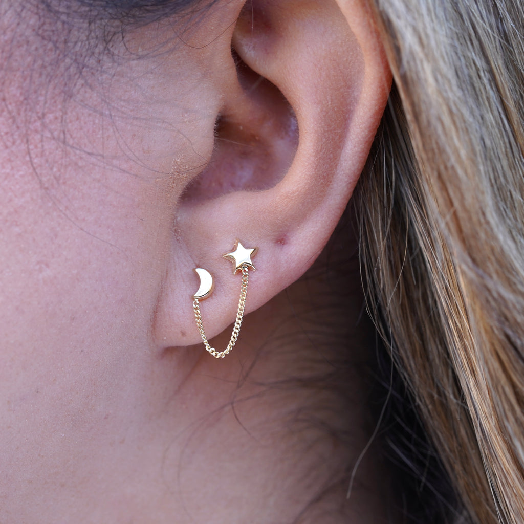 Model wearing 14K Gold Star & Moon Crawler Stud Earrings, showcasing their celestial star and moon design with a dainty, elegant curve along the ear.