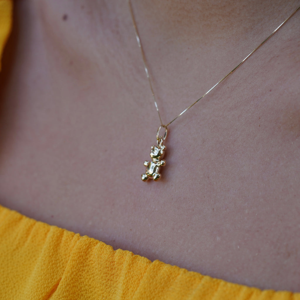 Side angle of a model wearing the 14K Real Gold Bear Pendant on a chain, highlighting the charm's unique craftsmanship and gold shine.