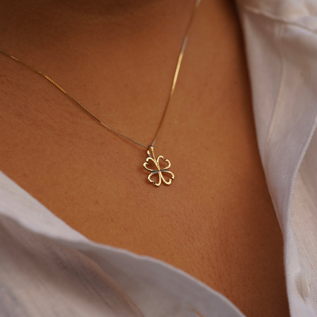 Model wearing the 14K Gold Heart Clover Pendant, showcasing its delicate heart-shaped clover design and radiant yellow gold finish.