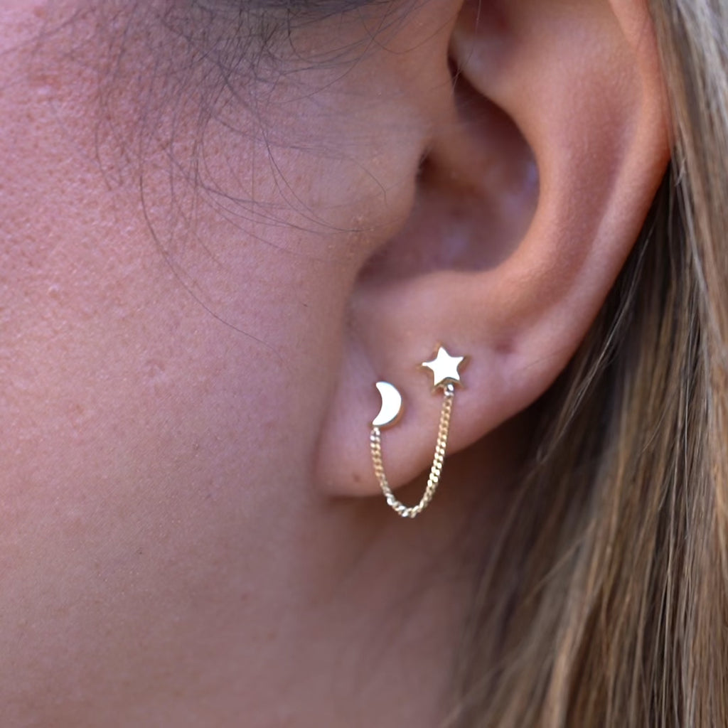 Video of a model wearing 14K Gold Star & Moon Crawler Stud Earrings, highlighting their celestial star and moon design, elegant curve along the ear, and secure screw-back closure from various angles