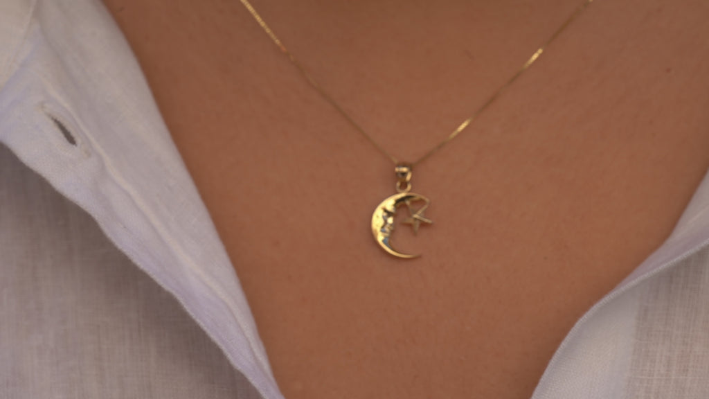 Video of a model wearing the 14K Gold Moon & Star Pendant, showcasing its celestial design with a polished crescent moon and star, highlighting its elegant fit and radiant yellow gold finish.