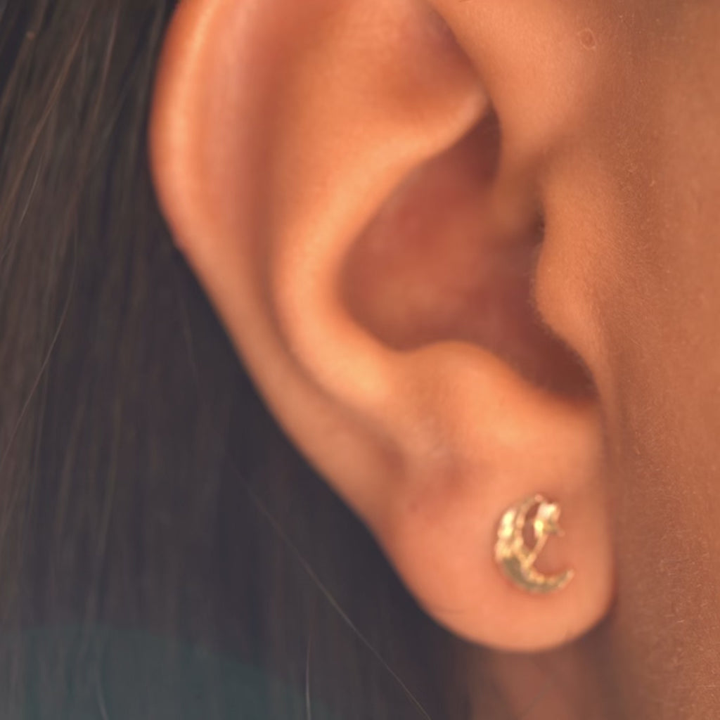 Video of a model wearing 14K Solid Gold Moon & Star Push Back Earrings, showcasing their delicate celestial design, polished yellow gold finish, and secure push-back closure from various angles.