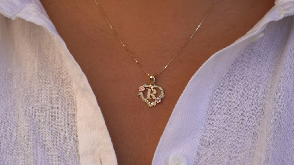 Model wearing the 14K Two-Tone Initial Heart Pendant with Letter R, showing the charm's elegant two-tone design in motion as it sparkles in yellow and rose gold.