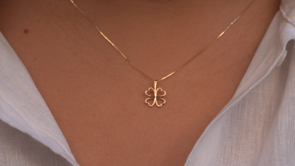 Video of a model wearing the 14K Gold Heart Clover Pendant, capturing its delicate heart-shaped clover design, polished yellow gold finish, and elegant movement.